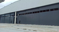 Zaprojektowane jednokierunkowe drzwi hangaru lotniczego Typowy projekt z furtką dostawca